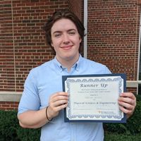 Parker Hewitt with award from undergraduate research symposium